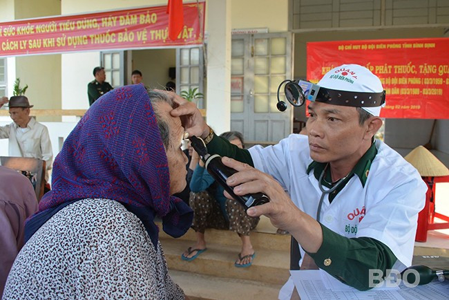 Trung tá Huỳnh Văn Phụng, nhân viên Ban Quân y BĐBP Bình Định khám mắt cho người dân ở xã Hoài Hải (TX Hoài Nhơn). Ảnh: T.BÌNH
