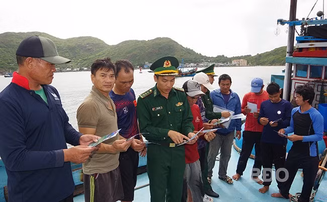 Cán bộ, chiến sĩ Đồn Biên phòng Cửa khẩu cảng Quy Nhơn phát tờ rơi tuyên truyền về chống khai thác IUU cho ngư dân, tháng 11.2024. Ảnh: CÔNG CƯỜNG