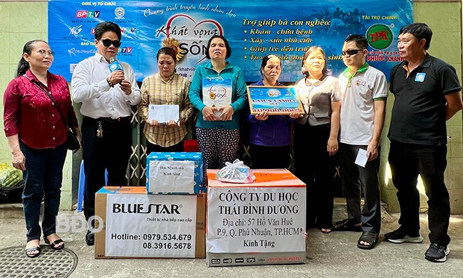 Ban tổ chức, nhà hảo tâm tặng quà cho 2 chị em mù lòa là bà Võ Thị Thu Hồng, Võ Thị Kim Loan, cùng bà Võ Thị Ánh Tuyết, ngày 11.4. Ảnh: D.L