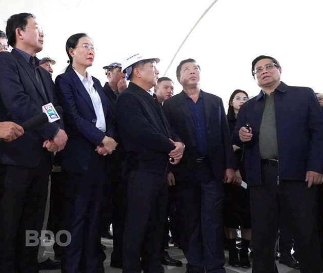 Thủ tướng Chính phủ Phạm Minh Chính (đầu tiên bên phải) nghe nhà thầu báo cáo tiến độ thực hiện cao tốc Quảng Ngãi - Hoài Nhơn. Ảnh: V.L
