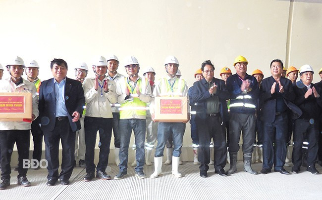 Thủ tướng Chính phủ Phạm Minh Chính (thứ 4 từ phải qua) tặng quà động viên người lao động thi công cao tốc Quảng Ngãi - Hoài Nhơn. Ảnh: V.L