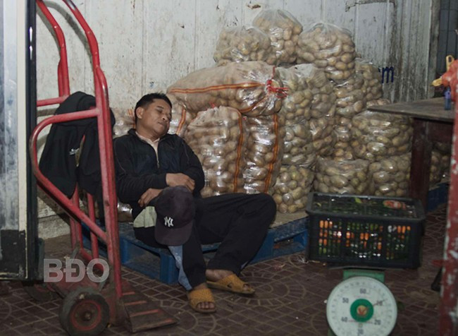 Ông Phan Đình Huy tranh thủ chợp mắt tại chợ, đợi chuyến hàng tập kết về để khuân vác.