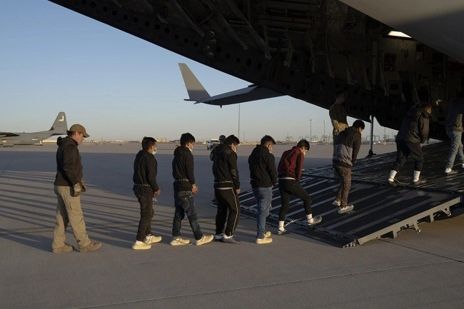 Đặc vụ thuộc Cơ quan Hải quan và Biên phòng Mỹ (CBP) áp giải người nhập cư trái phép lên vận tải cơ C-17 ở Fort Bliss. Ảnh: Reuters Đặc vụ thuộc Cơ quan Hải quan và Biên phòng Mỹ (CBP) áp giải người nhập cư trái phép lên vận tải cơ C-17 ở Fort Bliss. Ảnh: Reuters