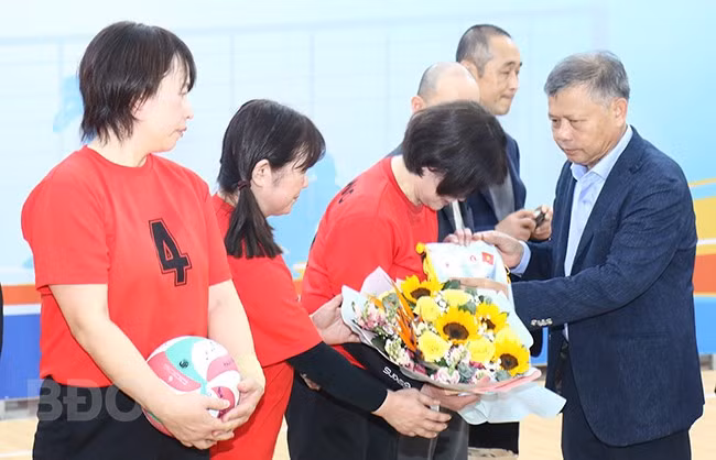 Phó Giám đốc Sở Ngoại vụ Võ Đình Kha tặng hoa cho đội bóng chuyền TP Izumisano trước khi trận đấu bắt đầu. Ảnh: HOÀNG QUÂN