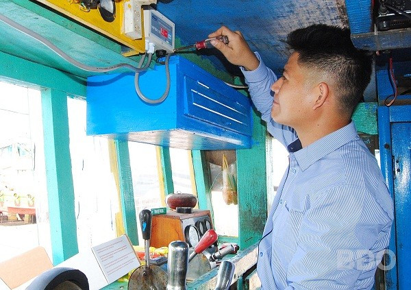 Cán bộ kỹ thuật Đài Thông tin duyên hải Quy Nhơn lắp thiết bị giám sát hành trình trên tàu cá của ngư dân Hoài Nhơn.