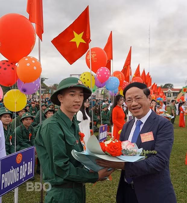 Đồng chí Phạm Anh Tuấn - Phó Bí thư Tỉnh ủy, Chủ tịch UBND tỉnh, Chủ tịch Hội đồng NVQS tỉnh, tặng hoa, động viên thanh niên TX An Nhơn lên đường thực hiện nghĩa vụ thiêng liêng với Tổ quốc. Ảnh: NGUYỄN HÂN