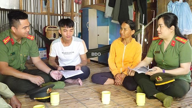 Lực lượng CA tuyên truyền về tội phạm trên không gian mạng tại gia đình anh Đinh Văn Vàng. Ảnh: M.N