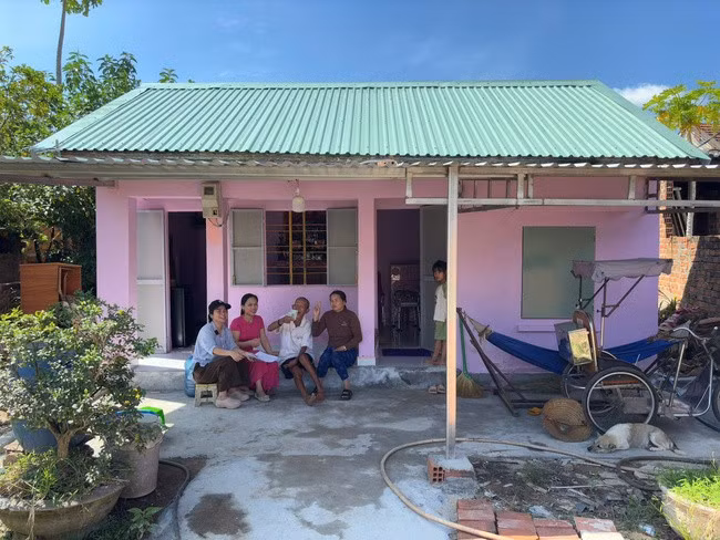 Chị Bùi Thị Mỹ Dân (bìa trái) cùng bà con hàng xóm chung vui với cụ Tám khi ngôi nhà được xây sửa xong. Ảnh: NVCC