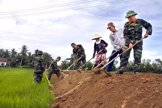 Cán bộ, chiến sĩ LLVT tỉnh giúp dân làm đường giao thông nội đồng tại thôn Phú Thiện (xã Mỹ Hòa, Phù Mỹ). Ảnh: SƠN PHẠM
