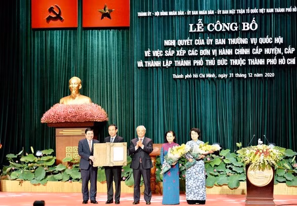 Phó chủ tịch Quốc hội Uông Chu Lưu (thứ ba từ trái qua) trao Nghị quyết của Ủy ban Thường vụ Quốc hội về thành lập TP Thủ Đức thuộc TP.HCM cho lãnh đạo TP.HCM - Ảnh: TỰ TRUNG