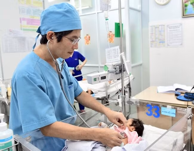Bác sĩ Đỗ Nguyên Tín khám cho một bé sơ sinh mắc bệnh tim bẩm sinh trước khi làm can thiệp tại Bệnh viện Nhi đồng 1. Ảnh: NVCC