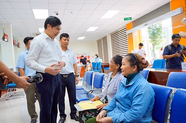 Phó Chủ tịch UBND tỉnh Lâm Hải Giang trò chuyện với người dân TP Quy Nhơn đến nộp hồ sơ thủ tục hành chính tại Trung tâm Phục vụ hành chính công tỉnh. Ảnh: N.M.