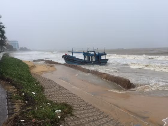 Một tàu cá bị sóng đánh dạt vô bờ biển trước Bệnh viện Quân y 13
