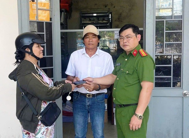 Trước sự chứng kiến của CA xã Phước An, chị Nguyễn Thị Lan (bên trái) trao trả chiếc điện thoại Iphone Xsmax cho ông Nguyễn Văn Trình. Ảnh: CA XÃ PHƯỚC AN