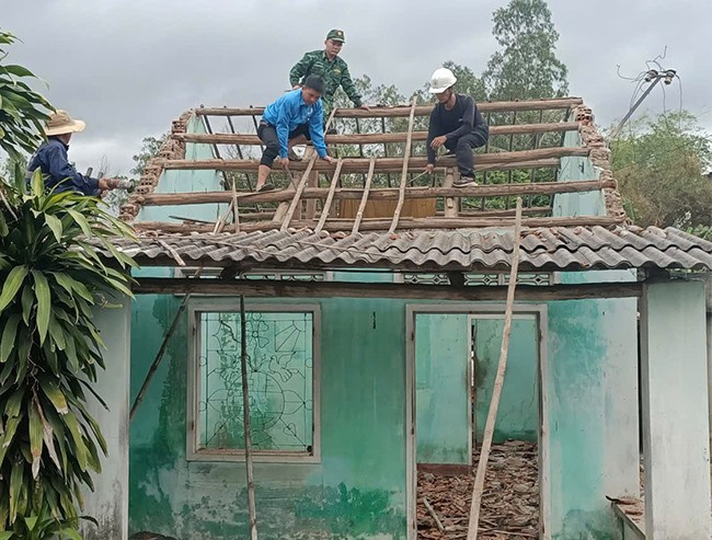 Thanh niên, cán bộ địa phương, LLVT trên địa bàn huyện Phù Cát tham gia hỗ trợ gia đình ông Đinh Văn Sơn tháo dỡ nhà, vận chuyển vật liệu xây dựng. Ảnh: ĐVCC