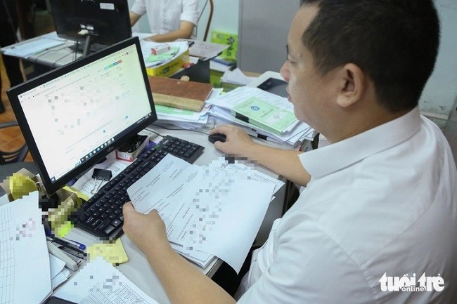 Cán bộ ngành bảo hiểm xã hội kiểm tra hồ sơ của người lao động và chủ sử dụng lao động. Ảnh: HÀ QUÂN Cán bộ ngành bảo hiểm xã hội kiểm tra hồ sơ của người lao động và chủ sử dụng lao động. Ảnh: HÀ QUÂN