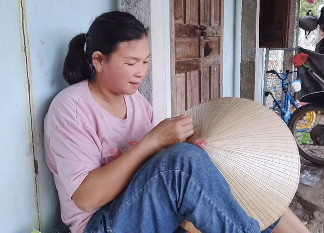 Chị Bùi Thị Minh Thư chằm nón. Ảnh: TRỌNG LỢI