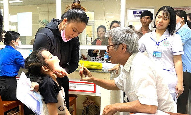 Các bác sĩ Trung tâm II - Trực tiếp hỗ trợ trẻ khuyết tật khám sàng lọc cho trẻ khuyết tật. Ảnh: M.H