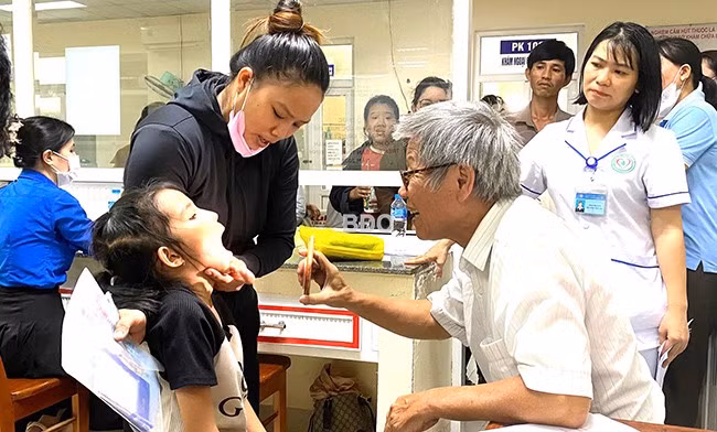Các bác sĩ Trung tâm II - Trực tiếp hỗ trợ trẻ khuyết tật khám sàng lọc cho trẻ khuyết tật. Ảnh: M.H Các bác sĩ Trung tâm II - Trực tiếp hỗ trợ trẻ khuyết tật khám sàng lọc cho trẻ khuyết tật. Ảnh: M.H
