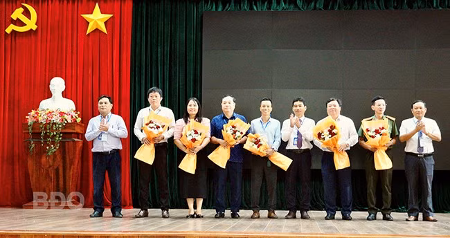 Trường CĐ Kỹ thuật Công nghệ Quy Nhơn tặng hoa cho các doanh nghiệp, đơn vị đồng hành cùng kỳ thi. Ảnh: N.M.