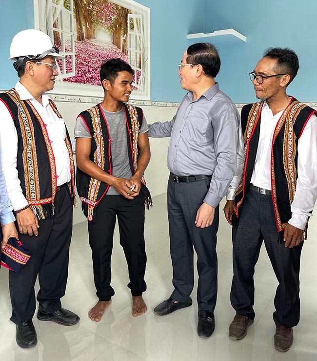 Chủ tịch UBND tỉnh Phạm Anh Tuấn (thứ 2 từ phải sang) chúc mừng gia đình anh Đinh Văn Canh (thứ 3 từ phải sang)vừa được hỗ trợ xây nhà theo chương trình xoá nhà tạm của huyện là đón điện lưới quốc gia. Ảnh: HẢI YẾN