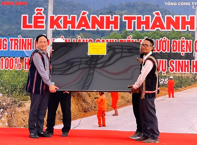 Chủ tịch UBND tỉnh Phạm Anh Tuấn (bìa trái) tặng tivi cho làng Canh Tiến. Ảnh: HẢI YẾN