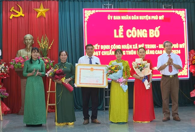 Thừa ủy quyền của Chủ tịch UBND tỉnh, lãnh đạo tỉnh và huyện Phù Mỹ trao Quyết định công nhận xã Mỹ Trinh đạt chuẩn NTM nâng cao năm 2024 cho Đảng bộ, chính quyền và nhân dân xã Mỹ Trinh. Ảnh: T.T