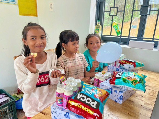 Các em nhỏ thôn 2, xã An Nghĩa dùng bánh liên hoan tại chương trình. Ảnh: Hội LHPN tỉnh