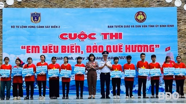 Lãnh đạo Bộ Tư lệnh Vùng Cảnh sát biển 2 và Ban Tuyên giáo và Dân vận Tỉnh ủy tặng biểu trưng hỗ trợ xe đạp cho các học sinh. Ảnh: D.Đ