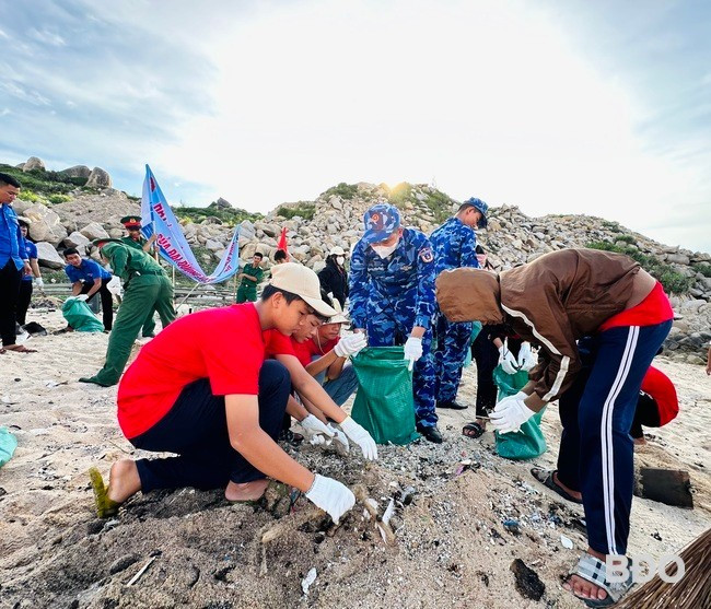 Các chiến sĩ Cảnh sát biển và học sinh dọn dẹp rác thải tại bờ biển xã Nhơn Châu. Ảnh: D.Đ Các chiến sĩ Cảnh sát biển và học sinh dọn dẹp rác thải tại bờ biển xã Nhơn Châu. Ảnh: D.Đ