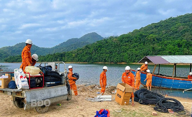 Công nhân Điện lực Phú Tài vận chuyển trang thiết bị điện bằng thuyền tới làng Canh Tiến. Ảnh: HẢI YẾN Công nhân Điện lực Phú Tài vận chuyển trang thiết bị điện bằng thuyền tới làng Canh Tiến. Ảnh: HẢI YẾN