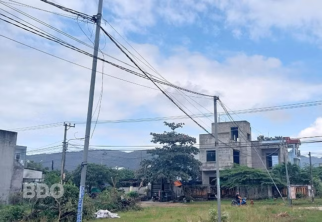 Chưa có trụ điện được xây dựng kiên cố, người dân tự trồng trụ và kéo điện từ rất xa về nhà, dễ gây mất an toàn điện. Ảnh: V.L