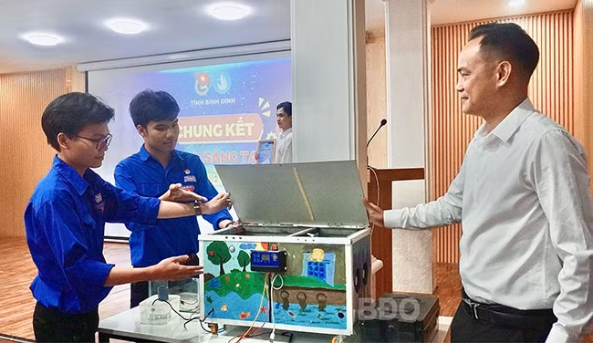 Nhóm học sinh Trường THPT Nguyễn Diêu giải thích với ban giám khảo về nguyên lý hoạt động của máy lọc không khí thông minh. Ảnh: D.L