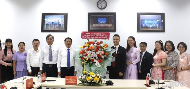 Chủ tịch UBND tỉnh Phạm Anh Tuấn (thứ 5, từ trái sang) tặng hoa chúc mừng Trường THPT FPT Quy Nhơn. Ảnh: M.H