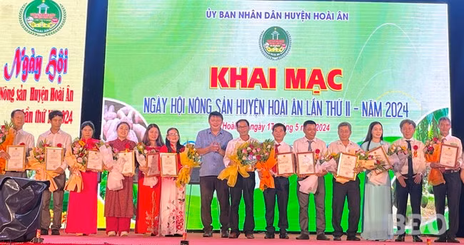 Lãnh đạo UBND huyện trao giấy chứng nhận OCOP cho các chủ thể. Ảnh: HẢI YẾN