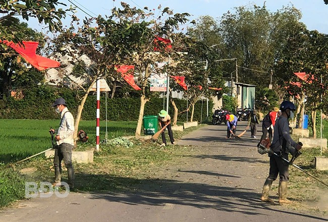 Người dân xã Phước Hưng phát quang, dọn cỏ dại trên các tuyến đường, tạo cảnh quan môi trường xanh, sạch. Ảnh: A.N
