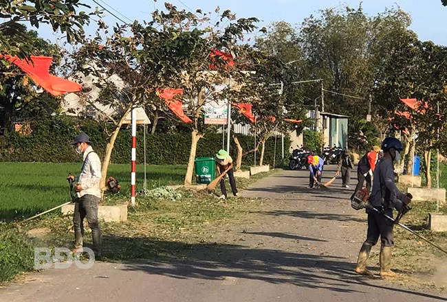 Người dân xã Phước Hưng phát quang, dọn cỏ dại trên các tuyến đường, tạo cảnh quan môi trường xanh, sạch. Ảnh: A.N