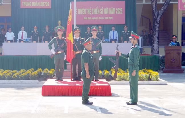 Chiến sĩ mới tiếp nhận vũ khí từ chỉ huy Trung đoàn Bộ binh 739. Ảnh: THẦN TÀI