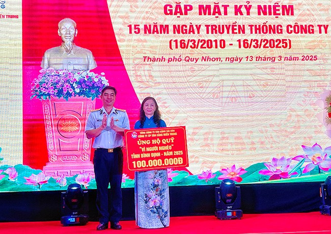 Lãnh đạo Công ty CP Tân Cảng miền Trung trao bảng tượng trưng ủng hộ Quỹ Vì người nghèo tỉnh Bình Định 100 triệu đồng. Ảnh: HẢI YẾN