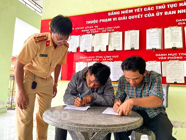 Anh Nguyễn Xuân Hòa (bìa phải) viết giấy cam kết không sử dụng xe độ chế tham gia giao thông. Ảnh: N.C Anh Nguyễn Xuân Hòa (bìa phải) viết giấy cam kết không sử dụng xe độ chế tham gia giao thông. Ảnh: N.C