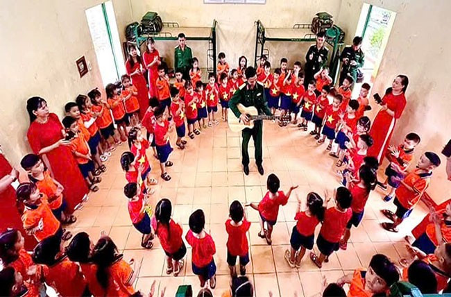 Cô và cháu Trường Mầm mon Sao Mai (thị trấn Phù Mỹ, huyện Phù Mỹ) giao lưu văn nghệ cùng bộ đội Lữ đoàn 572. Ảnh: QUANG THẮNG