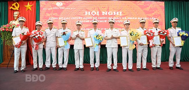 Đại diện Chi cục Thuế khu vực XIII trao quyết định bổ nhiệm chức vụ trưởng các phòng và đội trưởng các đội thuế liên huyện. Ảnh: T.SỸ