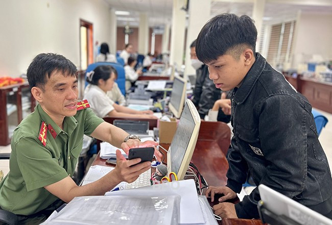 Cán bộ Phòng Hồ sơ nghiệp vụ (CA tỉnh) hướng dẫn công dân cách thực hiện các bước làm hồ sơ cấp phiếu lý lịch tư pháp. Ảnh: K.A