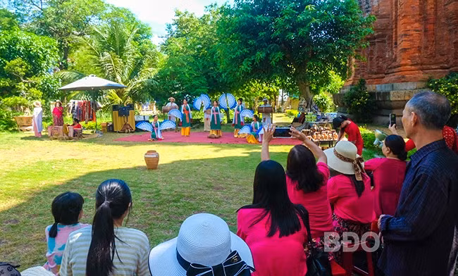 Du khách xem biểu diễn nghệ thuật Chăm tại tháp Đôi. Ảnh: ĐOAN NGỌC