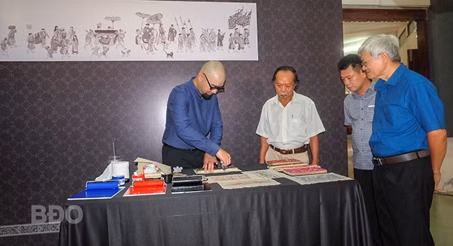 Giới thiệu mộc bản in hoa văn trên bia tiến sĩ tại Văn miếu - Quốc Tử Giám và tranh dân gian Đông Hồ. Ảnh: NGỌC NHUẬN