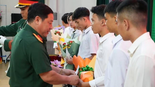 Đại tá Nguyễn Xuân Sơn tặng hoa và quà cho các thí sinh trúng tuyển. Ảnh: Đức Dũng