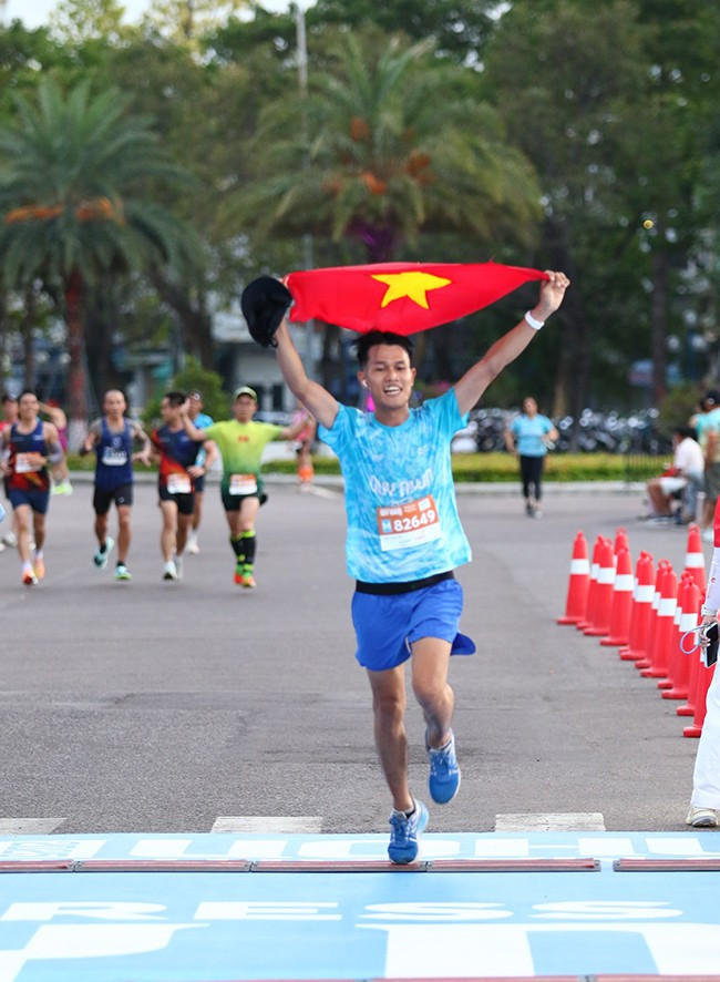 Một VĐV về đích đầy ấn tượng với lá quốc kỳ giơ cao. Một VĐV về đích đầy ấn tượng với lá quốc kỳ giơ cao.