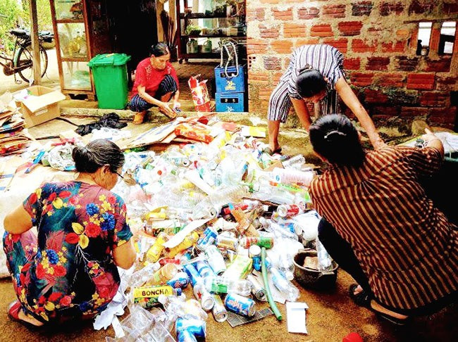 Phụ nữ khu phố 5, phường Bồng Sơn thu gom rác thải tái chế bán lấy tiền gây quỹ thực hiện chương trình Biến rác thải thành tiền. Ảnh. BẢO SƯƠNG