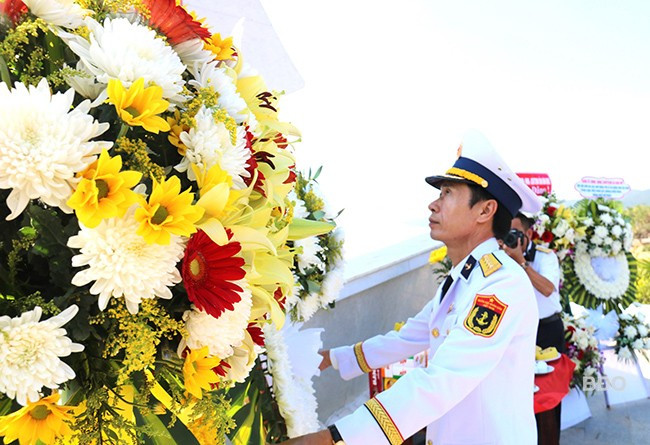 Đại tá Phạm Đình Thành - Phó Chính ủy Bộ Tư lệnh Vùng 3 Hải quân sửa hoa trước khi các đại biểu dâng hương. Ảnh: H.THU