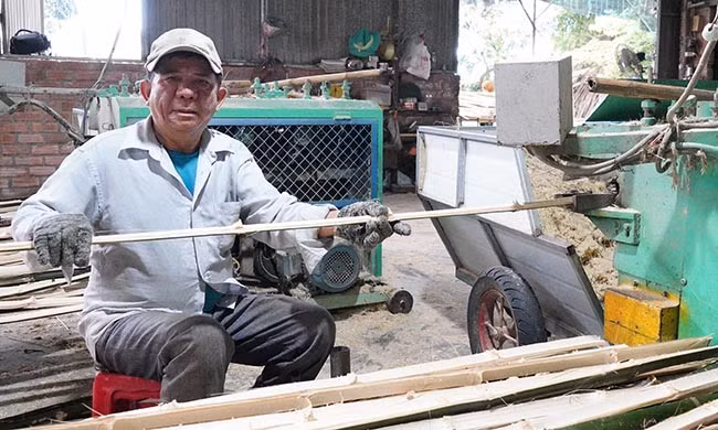 Ông Sanh sản xuất cọc tre từ thiết bị do mình sáng chế. Ảnh: N.H